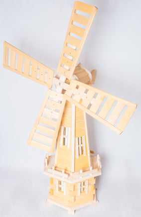 Garden windmill featuring wooden blades and tower, gracefully rotating in the wind, enhancing the visual appeal of the outdoor environment.